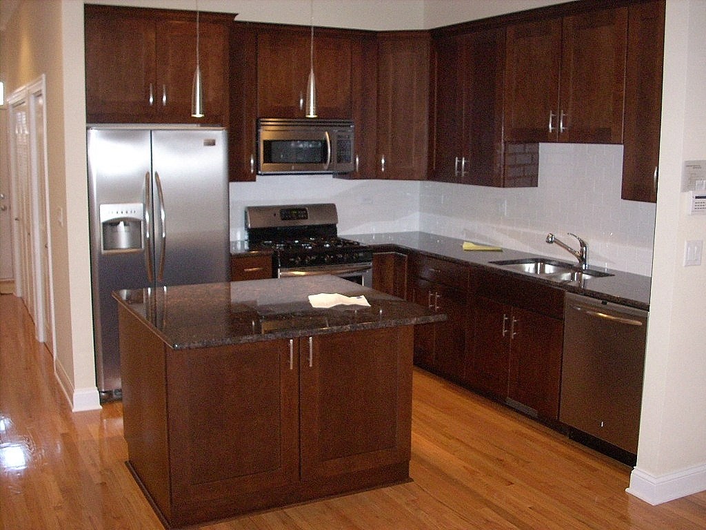 a kitchen with wooden cabinets and stainless steel appliances