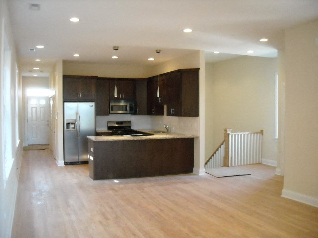 an empty kitchen with a stove and a refrigerator