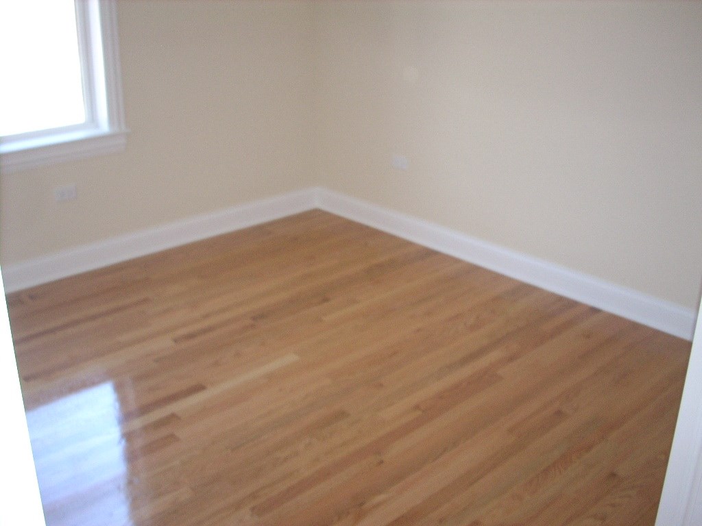 an empty room with wooden floors and a window