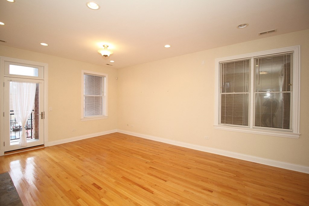 a living room with a hard wood floor and two windows