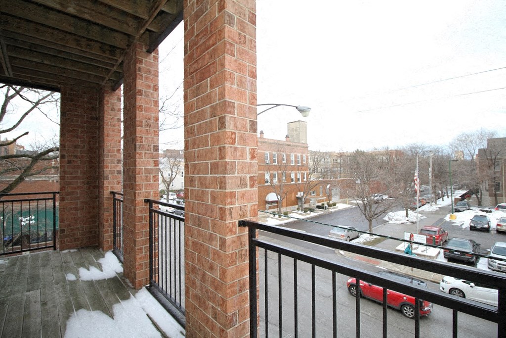 a balcony with a view of a street and cars in the snow