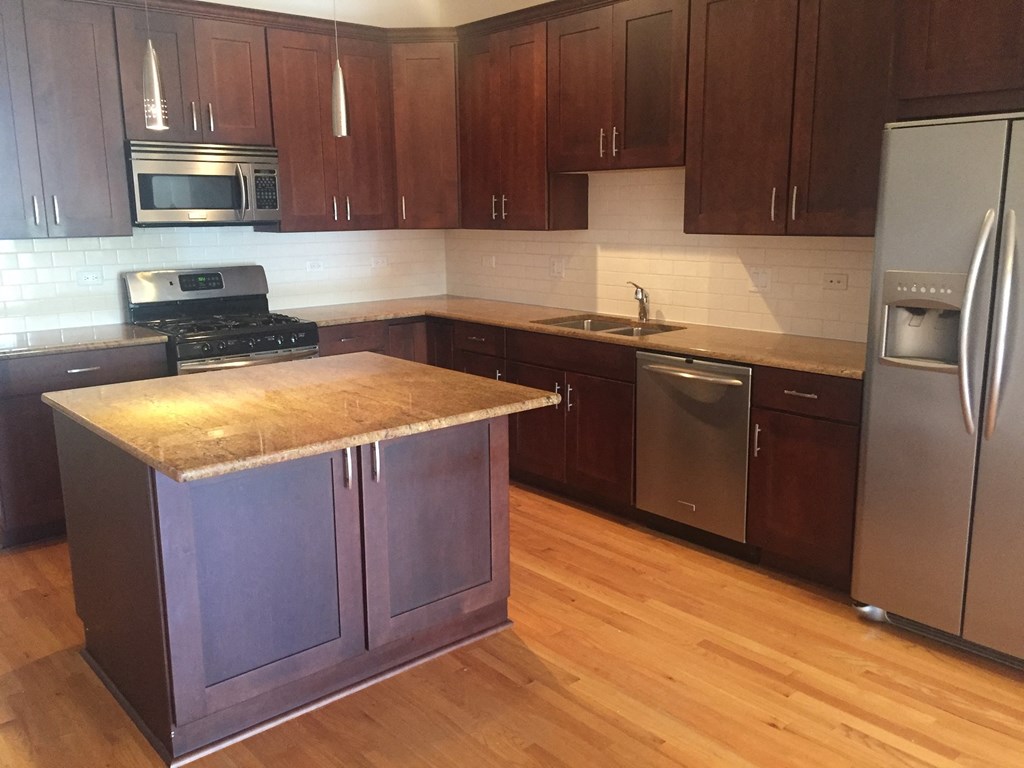 a kitchen with wooden cabinets and stainless steel appliances