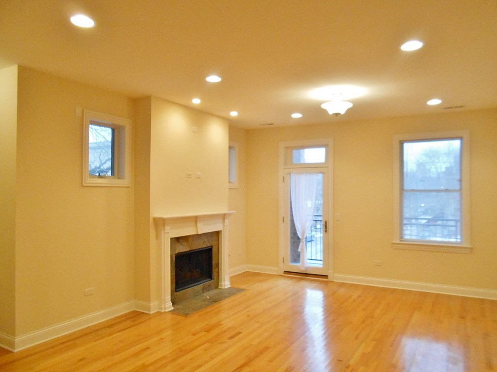 the living room of an empty house with a fireplace