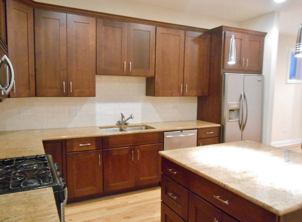 an empty kitchen with wooden cabinets and a counter top