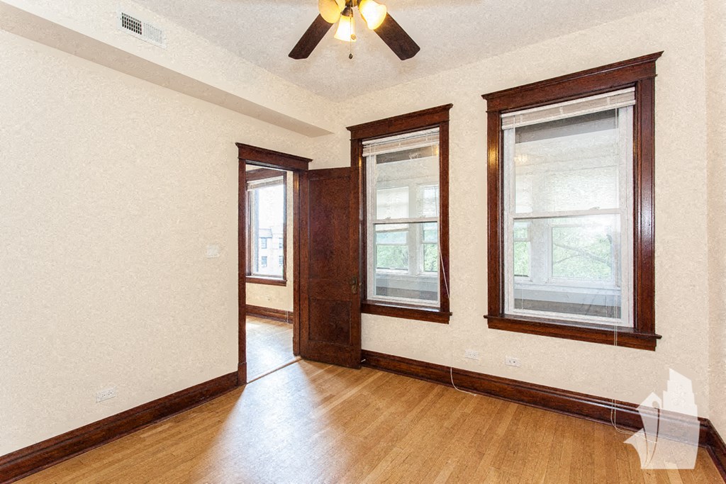 a living room with a wood floor and a ceiling fan