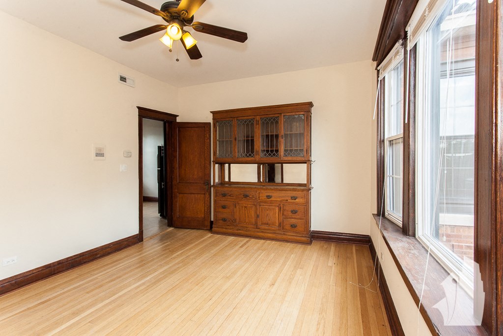 an empty living room with wood floors and a large window