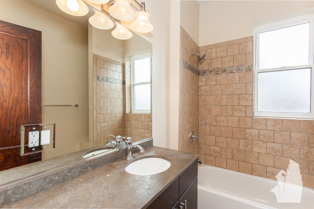 a bathroom with a sink and a tub and a mirror