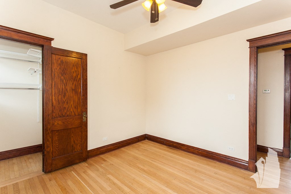 an empty living room with a wooden floor and a closet