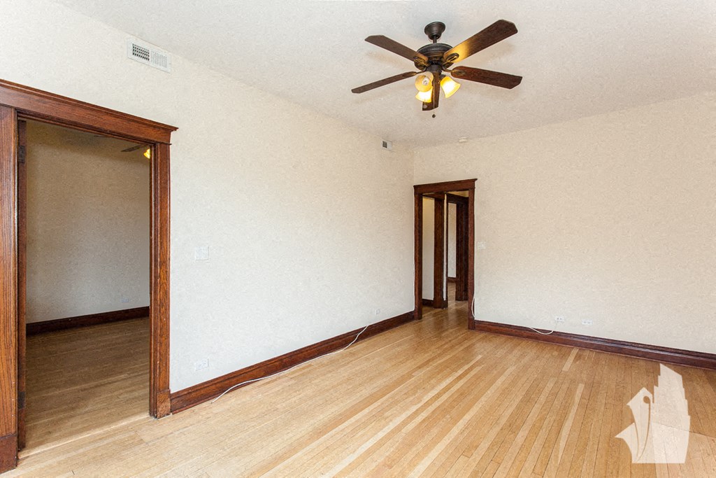 a living room with wood floors and a ceiling fan