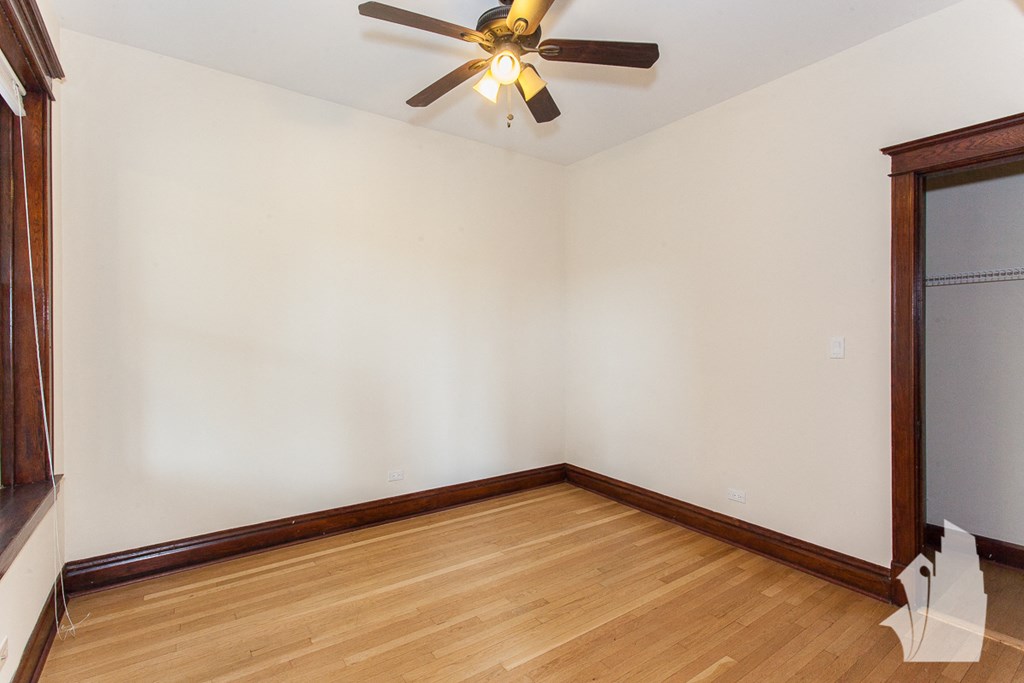 an empty room with wooden floors and a ceiling fan