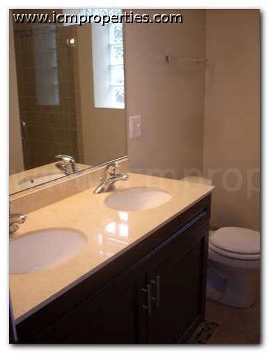 a bathroom with two sinks and a toilet and a mirror