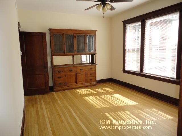 a living room with a wooden floor and a cabinet