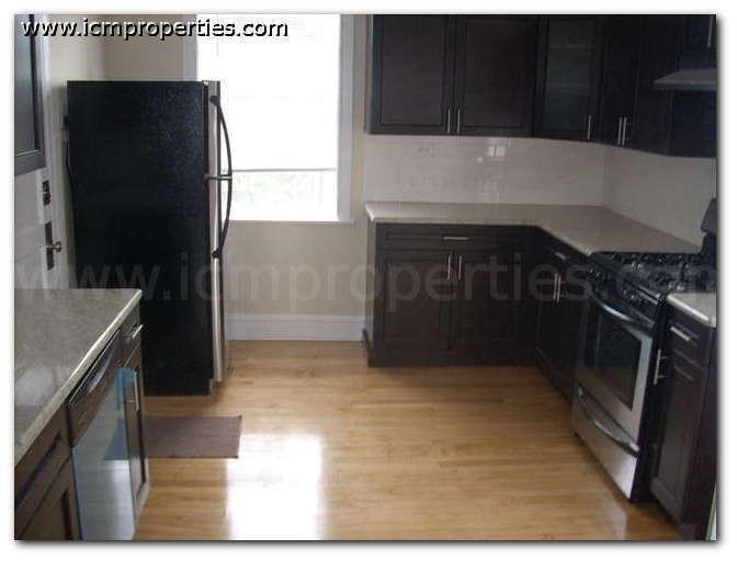 a kitchen with black appliances and wooden floors