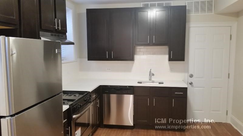 a kitchen with black cabinets and stainless steel appliances