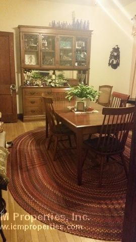 a dining room with a wooden table and chairs
