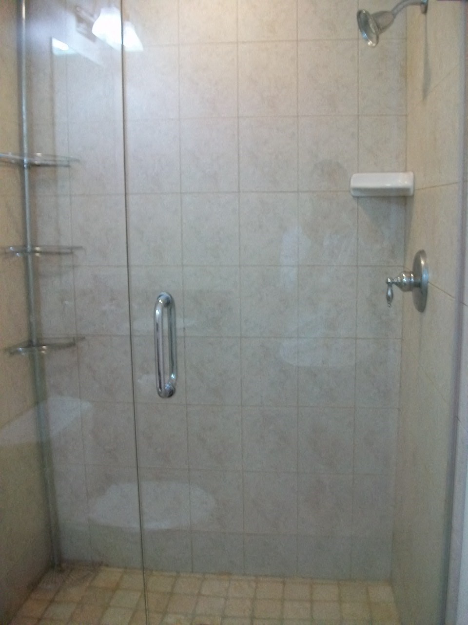 a white tiled shower with a glass door