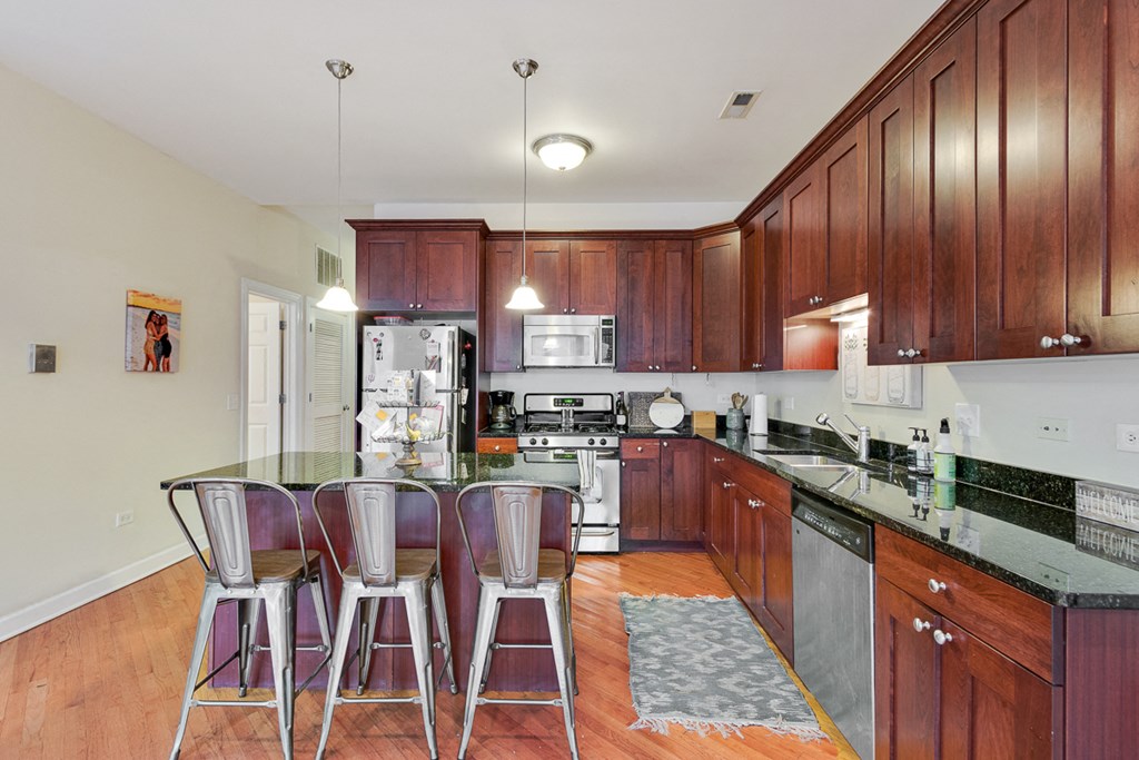 a kitchen with stainless steel appliances and bar stools