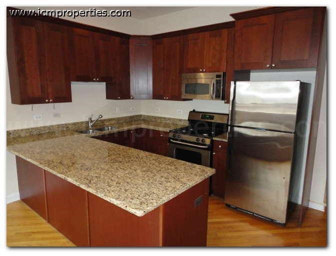 a kitchen with a granite counter top and stainless steel refrigerator