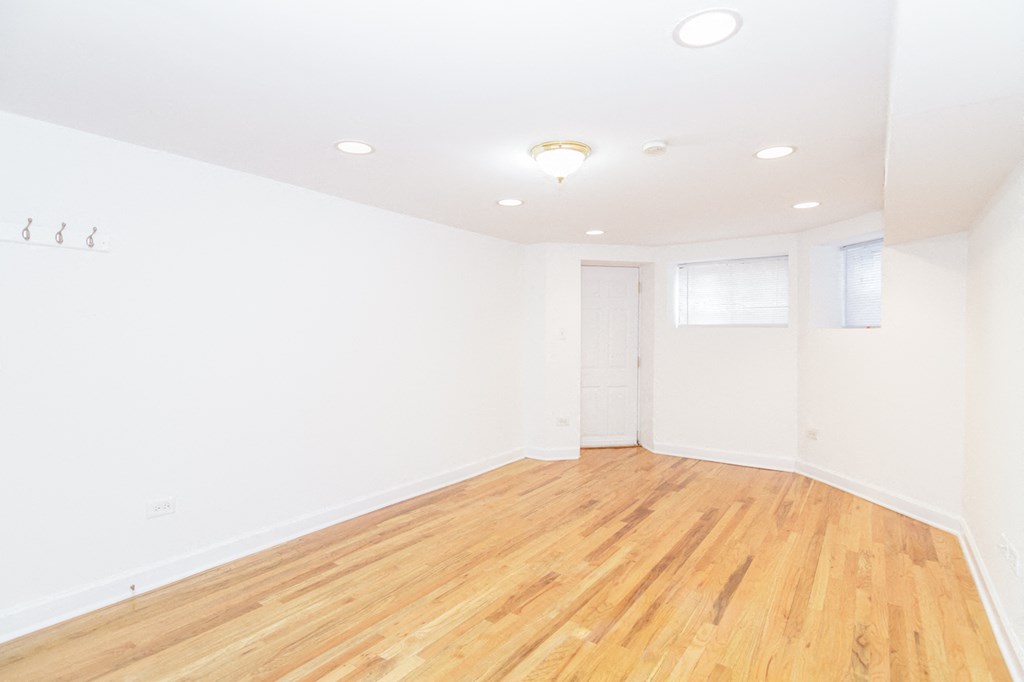 an empty living room with white walls and wood floors