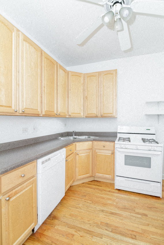 a kitchen with white appliances and wooden cabinets