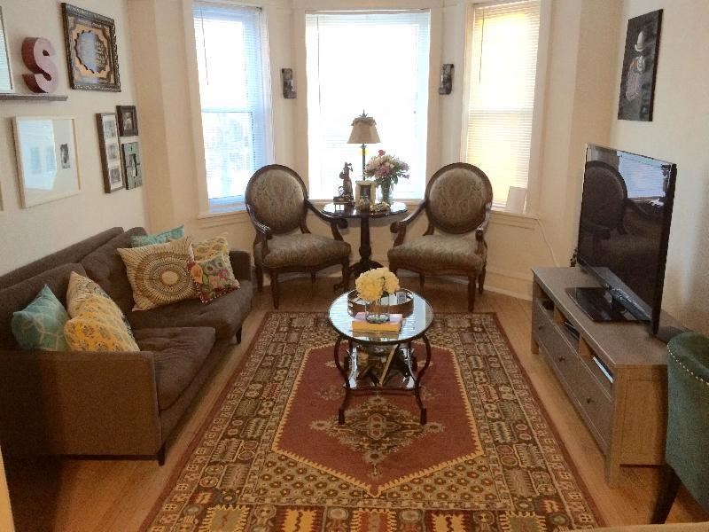 a living room with a couch and chairs and a tv
