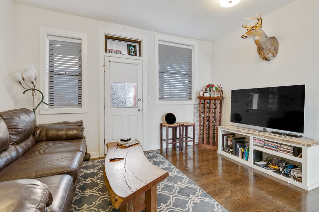 a living room with a leather couch and a television