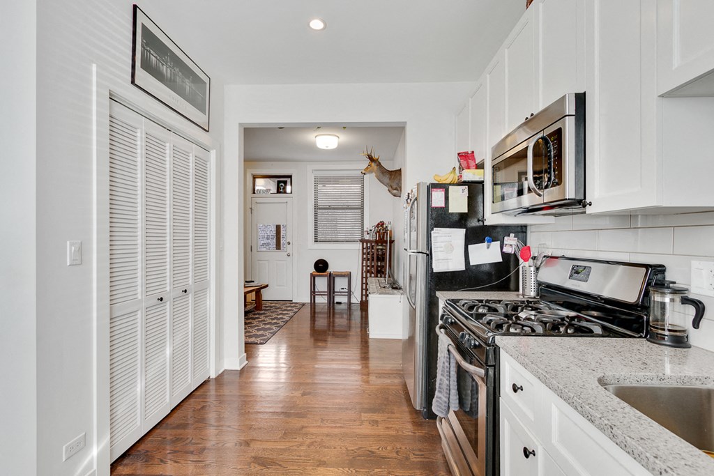 a kitchen with white cabinets and a stove and a refrigerator