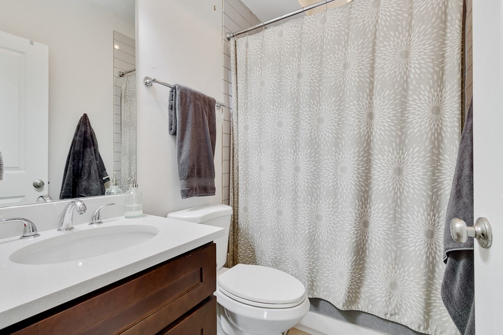 a bathroom with a shower curtain and a sink and a toilet