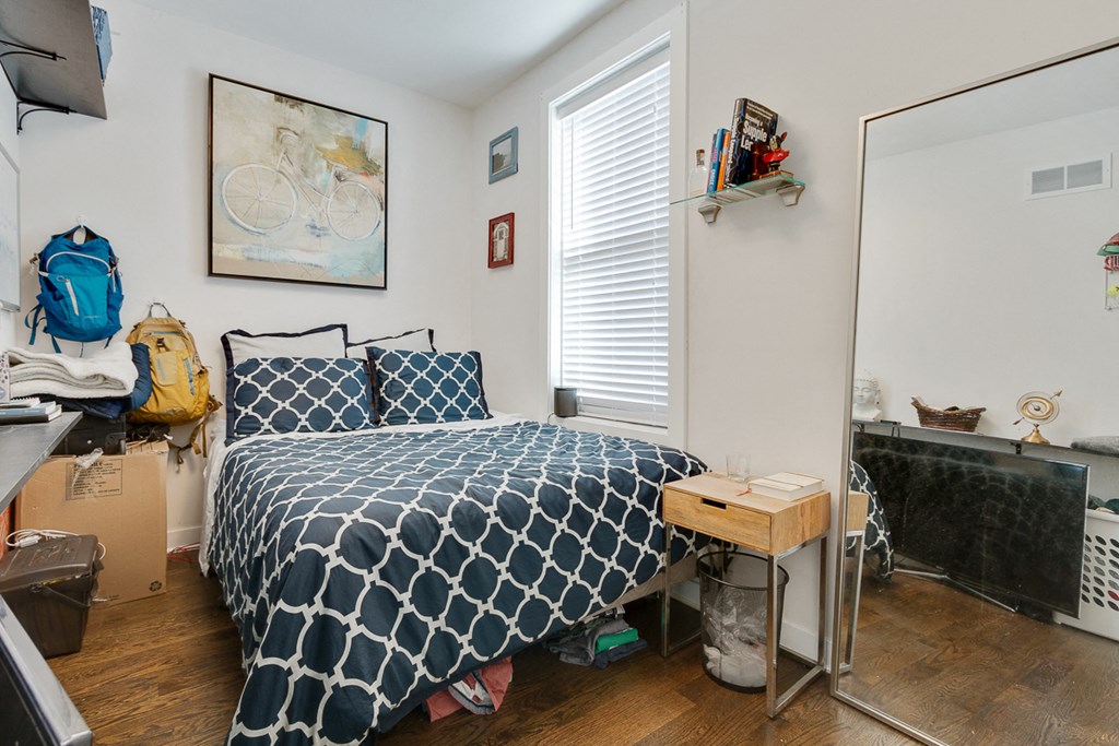 a bedroom with a bed with a blue and white comforter