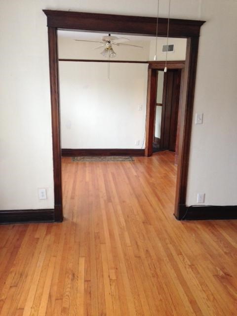 a living room with a wooden floor and a white wall