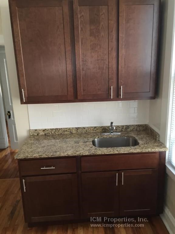 a kitchen counter with a sink and cabinets