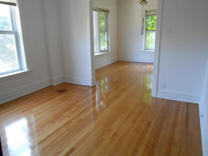 an empty living room with a wooden floor