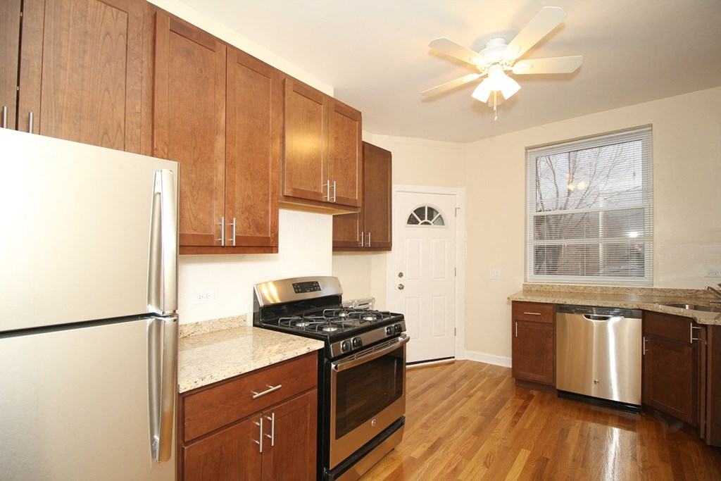 a kitchen with wooden cabinets and stainless steel appliances