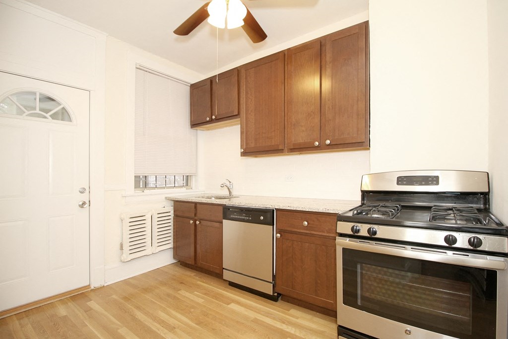 a kitchen with wooden cabinets and stainless steel appliances