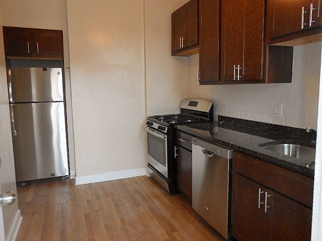 a kitchen with stainless steel appliances and wooden floors