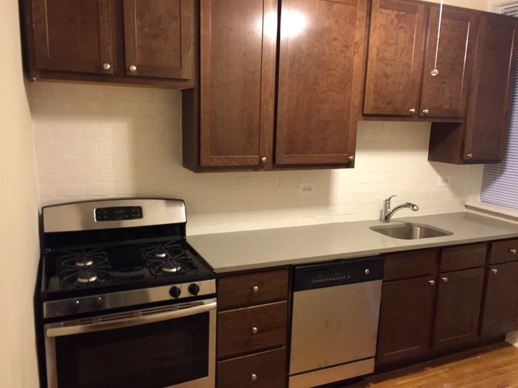 a kitchen with wooden cabinets and a stove and a sink