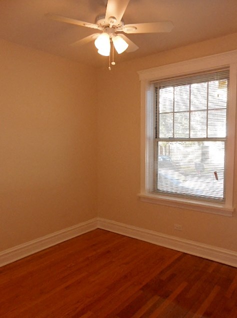 an empty room with a ceiling fan and a window