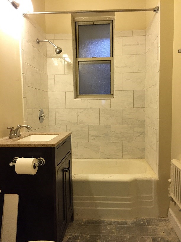 a bathroom with a shower and a sink and a window