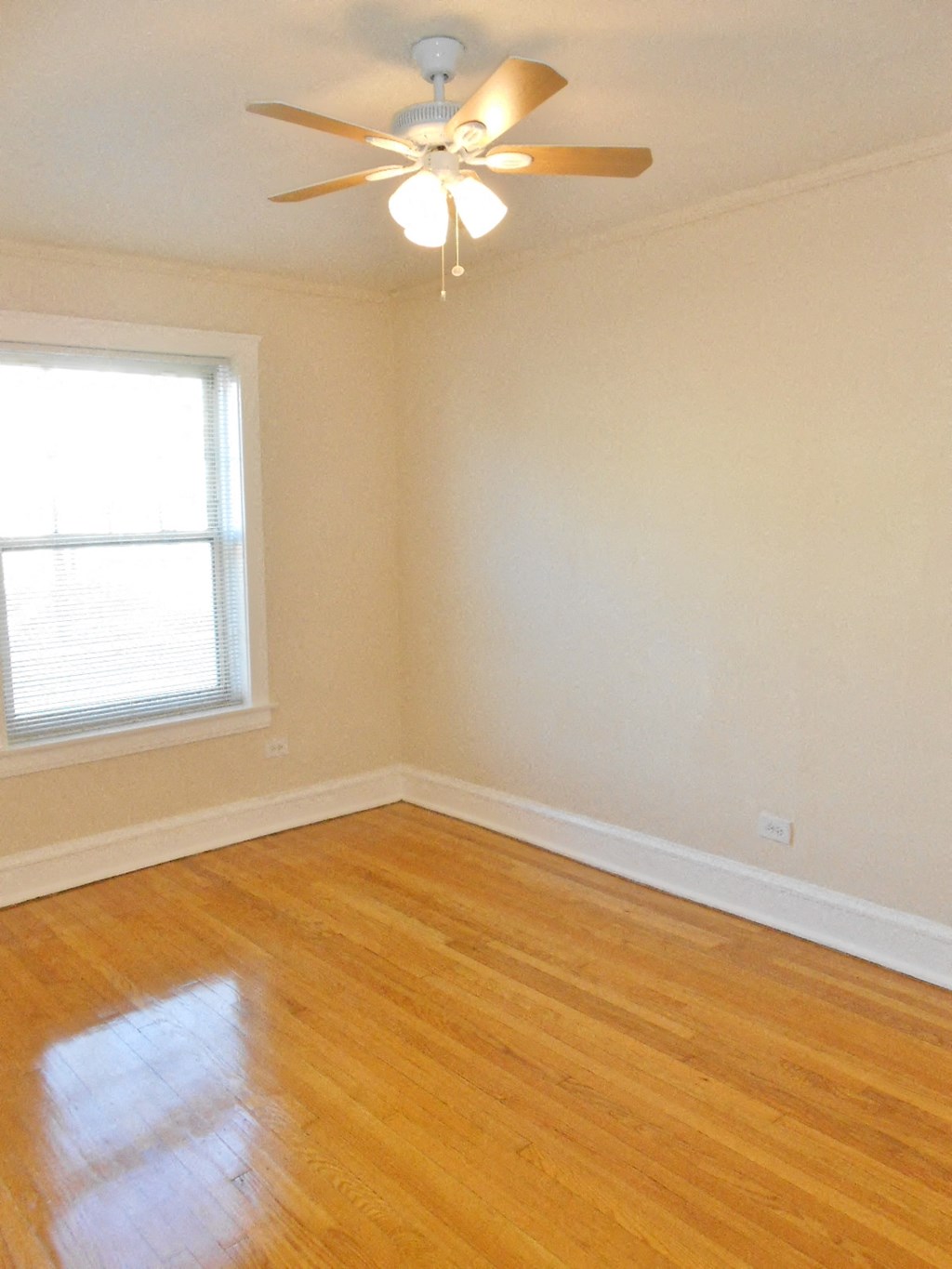 an empty room with a ceiling fan and a window