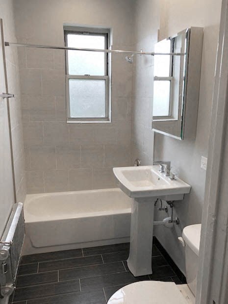 a white bathroom with a sink and a bath tub