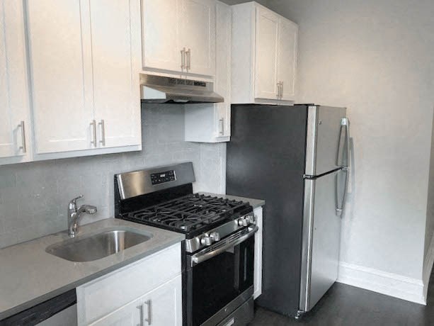 a kitchen with a stove and refrigerator and a sink