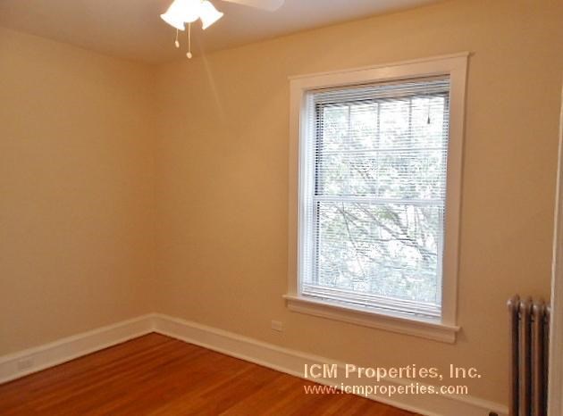a living room with a large window and a wooden floor