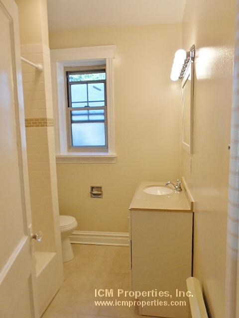 a bathroom with a sink toilet and a window