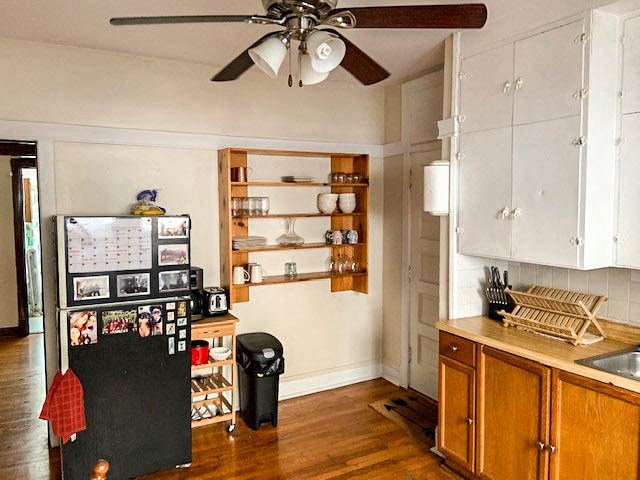 a kitchen with a refrigerator and a ceiling fan