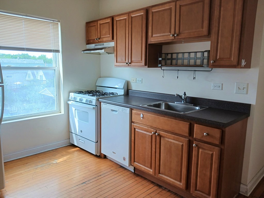 a kitchen with a stove and a sink and a window