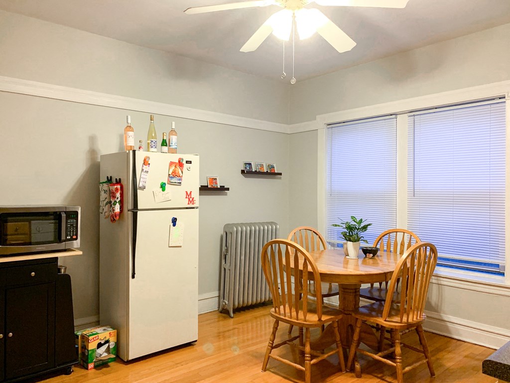 a dining room with a table and chairs and a refrigerator