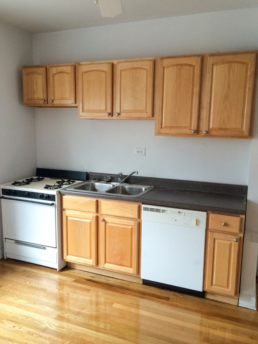 a kitchen with wooden cabinets and a stove and a sink