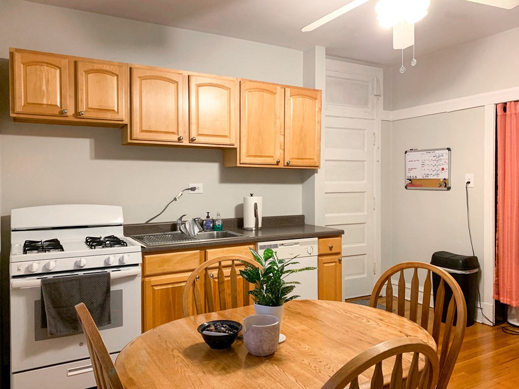 a kitchen and dining room with wooden cabinets and a wooden table