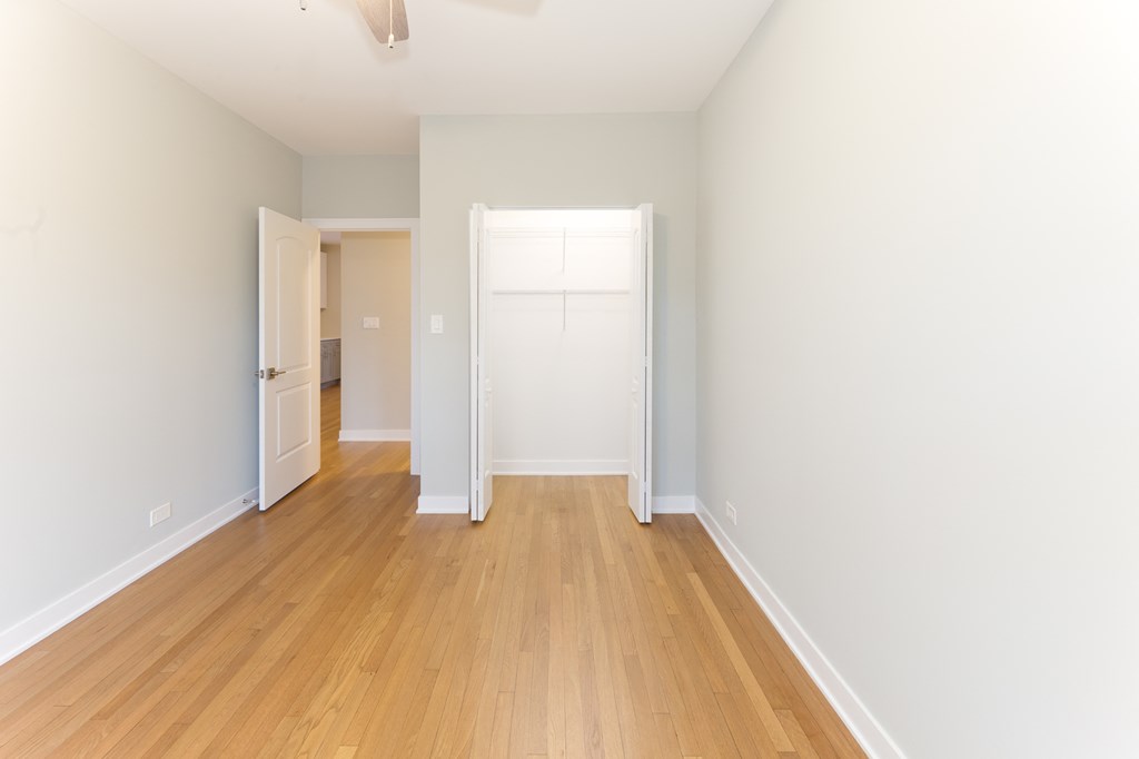 a living room with a hard wood floor and white walls