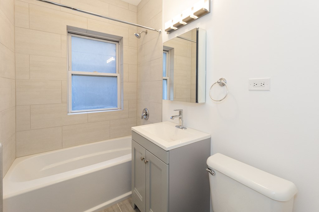 a bathroom with a tub and a sink and a mirror
